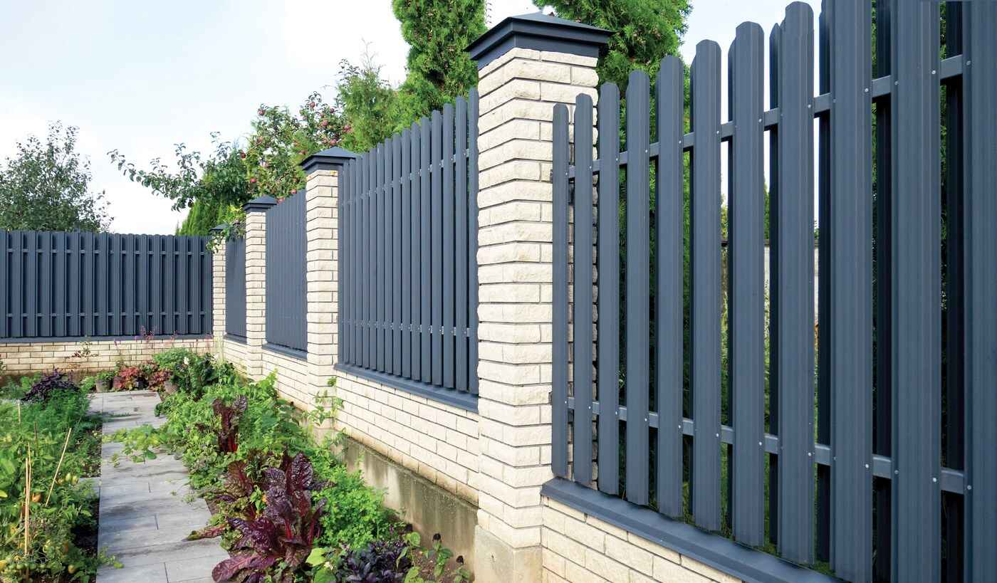 Geofenz metal fence installation along a brick boundary wall